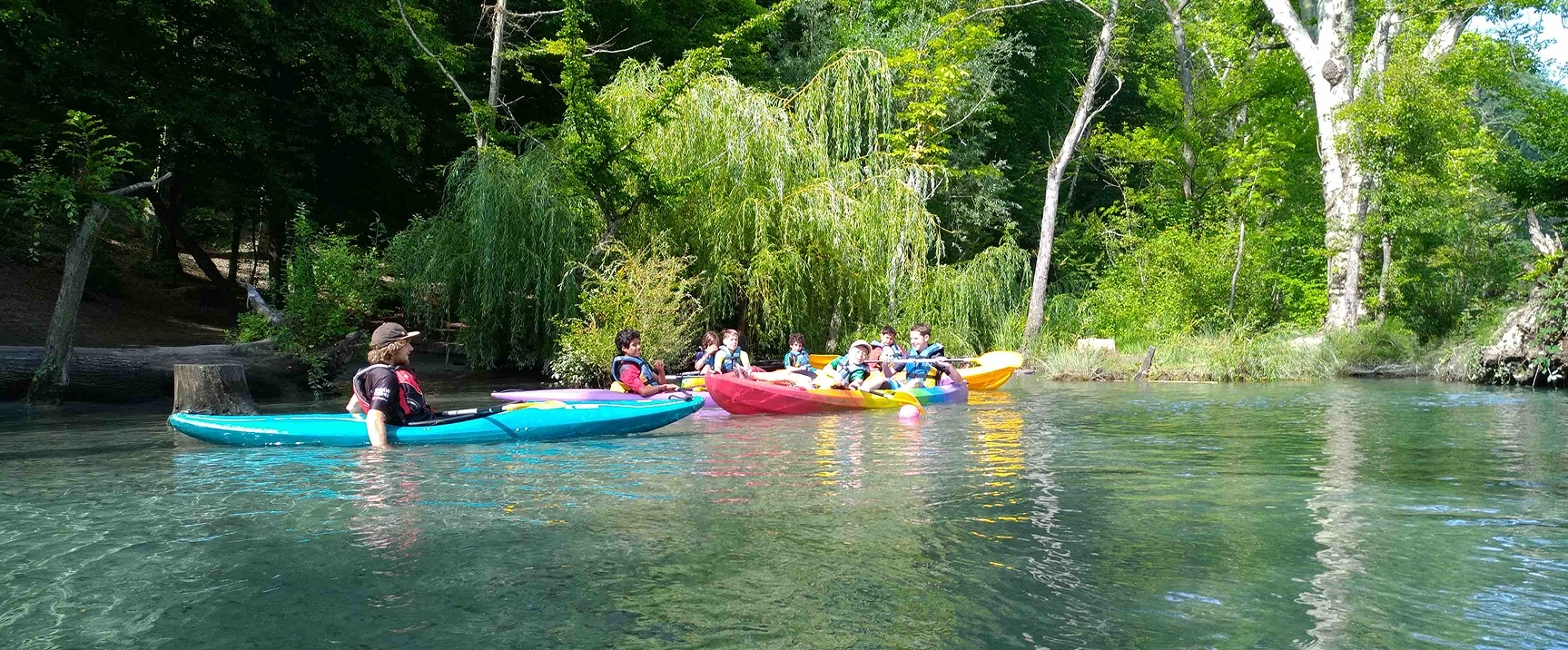 moniteur de canoë et enfant en canoë sur une rivière calme