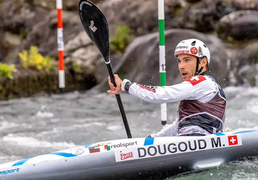 Homme en action sur un canoë en rivière avec barre de slalom